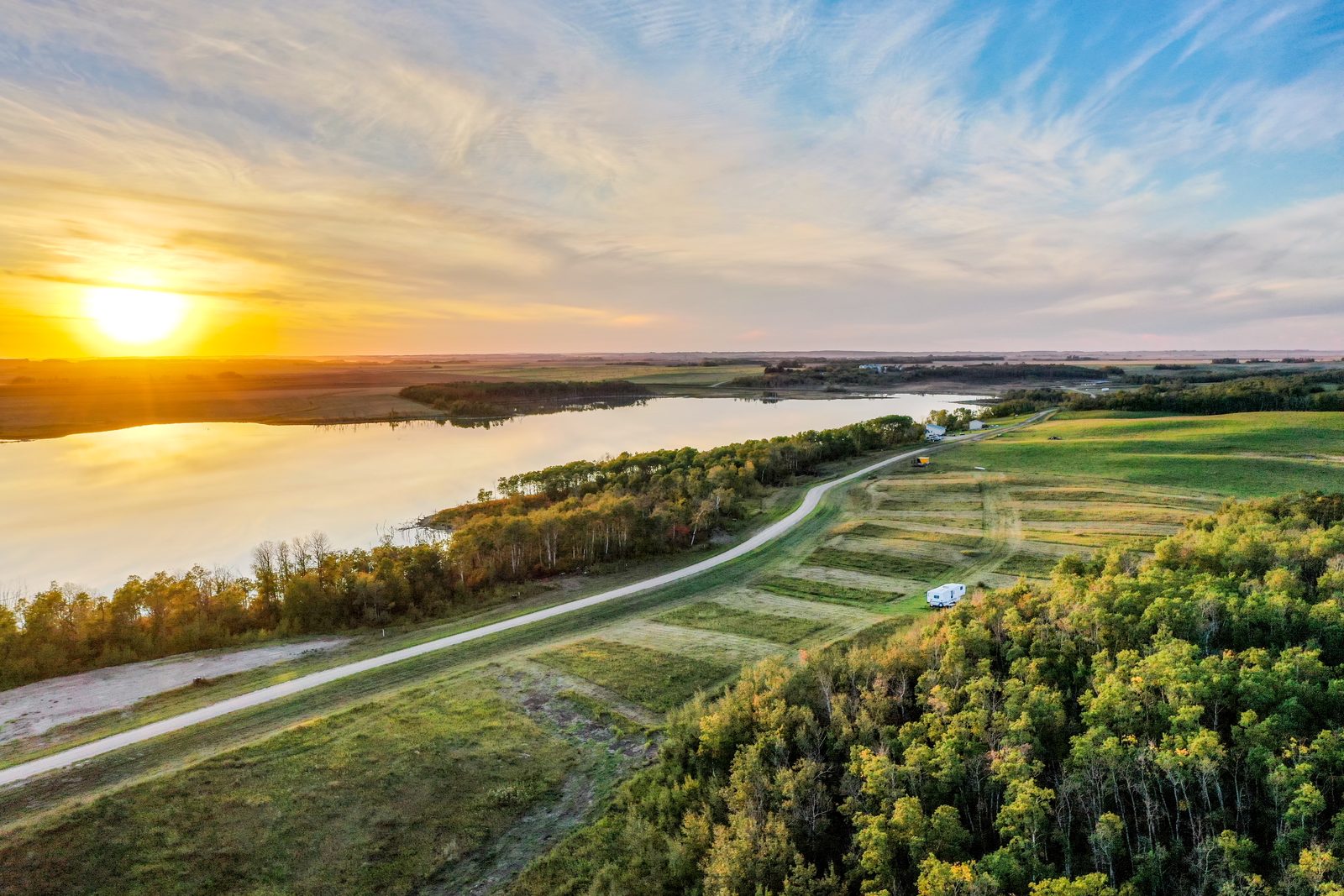Sunset over Shannon Lake, Saskatchewan, with the road running along the wooded shoreline